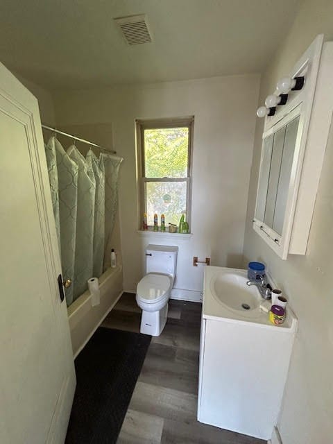 full bathroom featuring shower / bath combo, wood-type flooring, vanity, and toilet