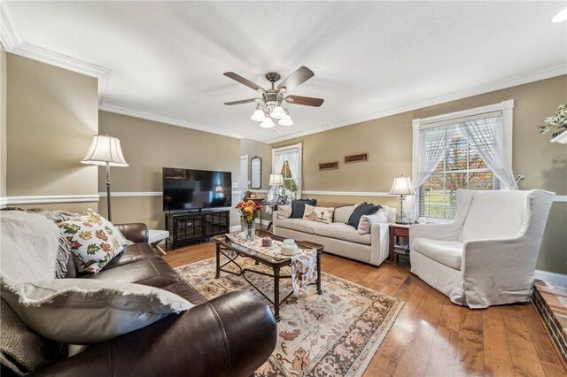 living room featuring ceiling fan, crown molding, and light hardwood / wood-style flooring