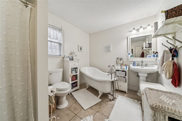 bathroom with a tub to relax in, tile patterned floors, and toilet