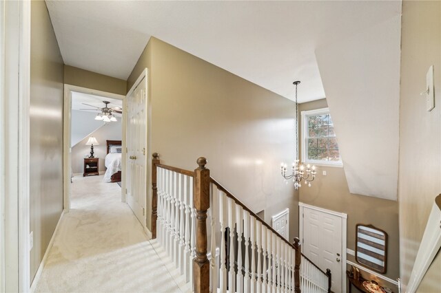 corridor featuring a chandelier and light carpet