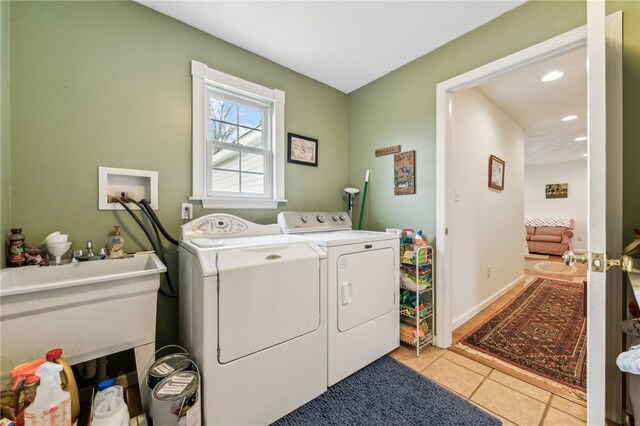 laundry room with washer and dryer and light tile patterned floors