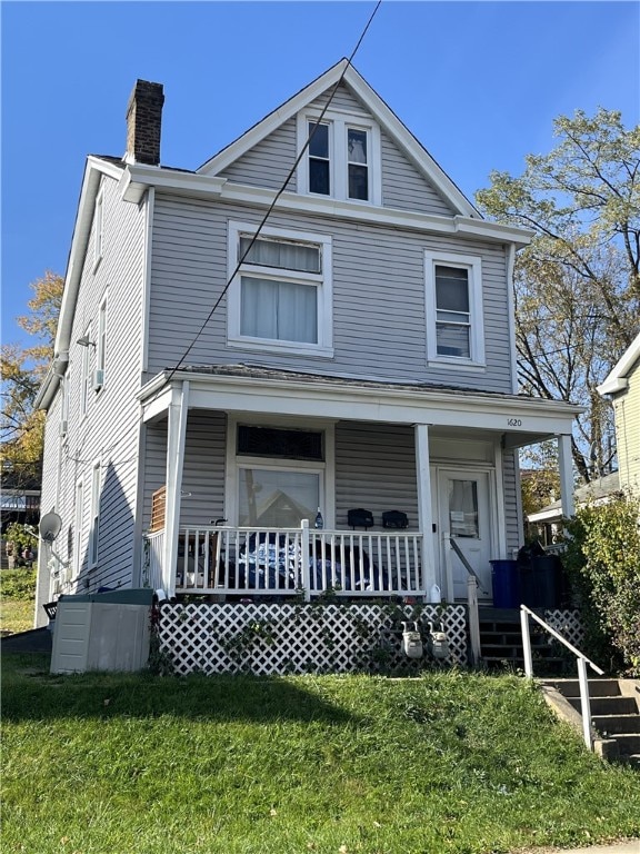 view of front of property featuring covered porch and a front lawn