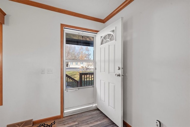 doorway to outside with ornamental molding and dark hardwood / wood-style floors