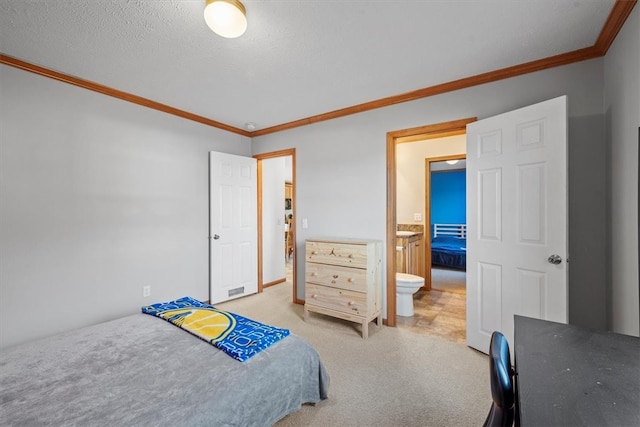 bedroom with a textured ceiling, light colored carpet, crown molding, and ensuite bathroom