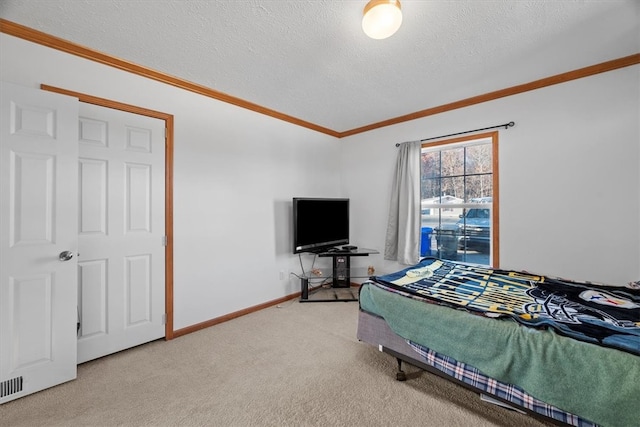 bedroom featuring ornamental molding, light colored carpet, and a textured ceiling