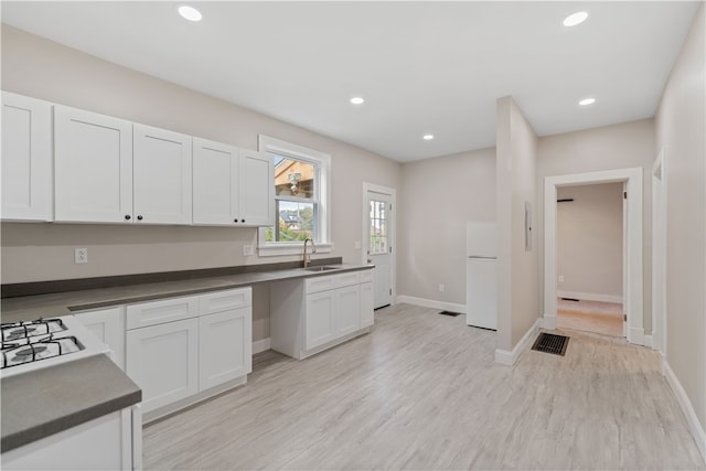 kitchen featuring light hardwood / wood-style flooring, white appliances, sink, and white cabinets