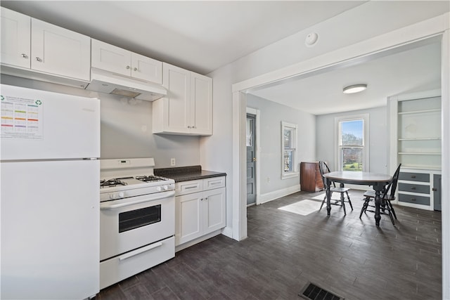 kitchen with white appliances, dark hardwood / wood-style floors, and white cabinets