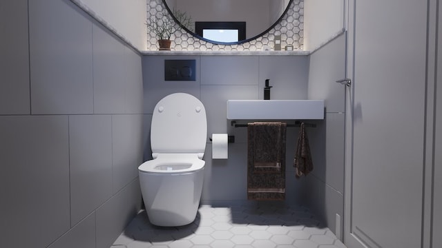 bathroom with tile walls, tile patterned flooring, sink, and toilet