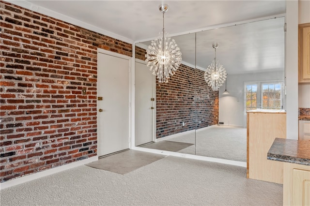 unfurnished dining area featuring light colored carpet, brick wall, and a notable chandelier