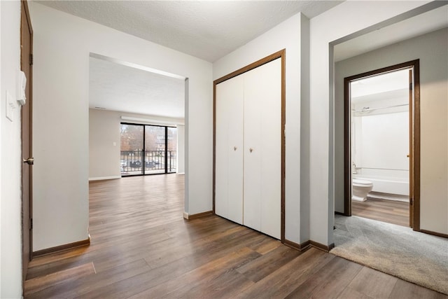 hall featuring a textured ceiling and dark hardwood / wood-style floors