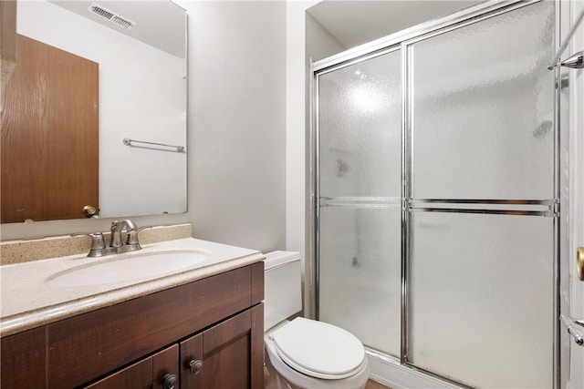 bathroom featuring vanity, toilet, and an enclosed shower