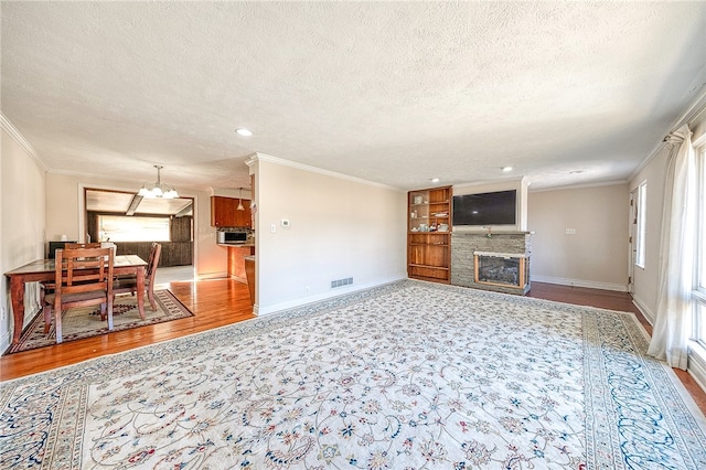 living room with hardwood / wood-style floors, crown molding, and a textured ceiling