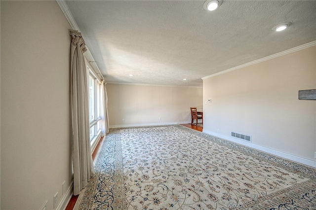 empty room featuring a textured ceiling and ornamental molding