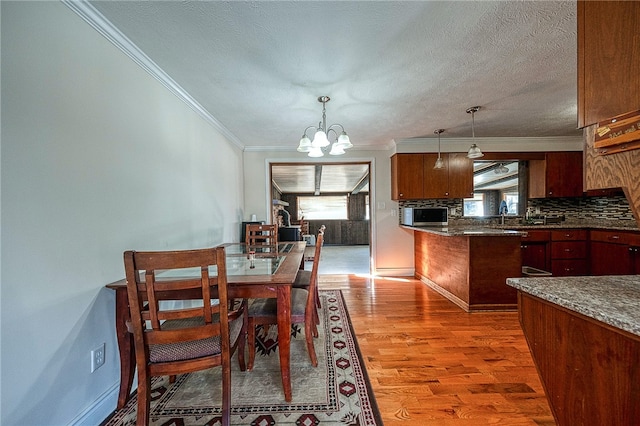 dining space featuring light hardwood / wood-style floors, plenty of natural light, a notable chandelier, and ornamental molding