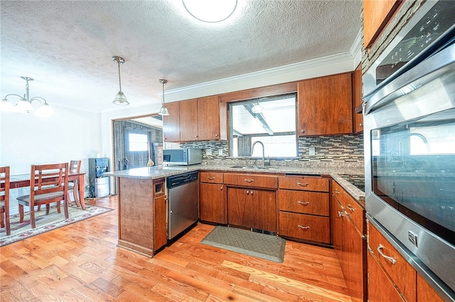 kitchen featuring light hardwood / wood-style flooring, kitchen peninsula, sink, and plenty of natural light