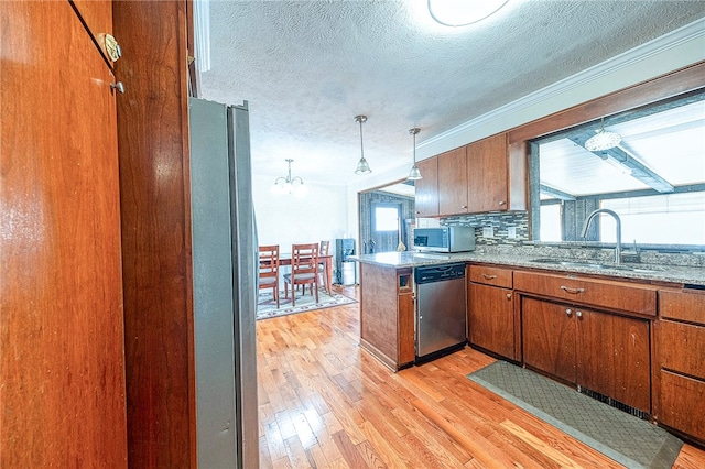 kitchen featuring kitchen peninsula, a healthy amount of sunlight, light wood-type flooring, and appliances with stainless steel finishes