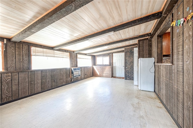 unfurnished room featuring wood walls, wood ceiling, and heating unit