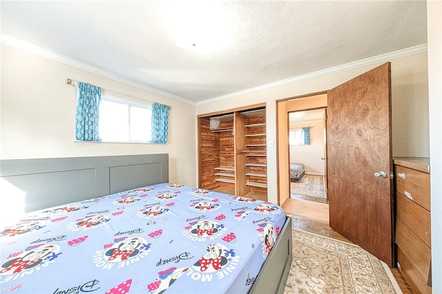 bedroom with a closet, light wood-type flooring, and ornamental molding