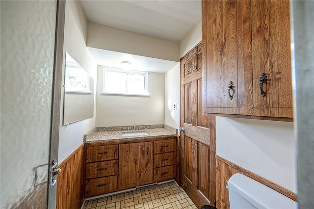 bathroom with wood walls, vanity, and toilet