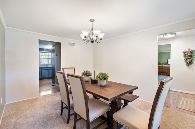 dining area with a chandelier, light hardwood / wood-style flooring, and ornamental molding