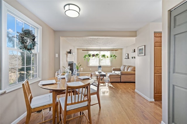 dining space with light wood-type flooring and a textured ceiling