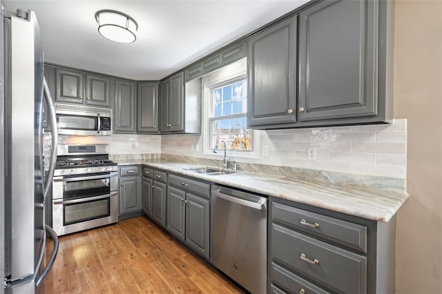 kitchen featuring sink, stainless steel appliances, gray cabinets, and light hardwood / wood-style flooring