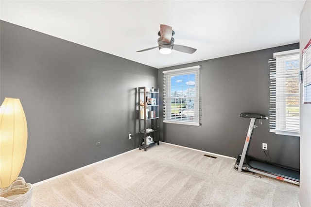 workout room featuring light colored carpet and ceiling fan