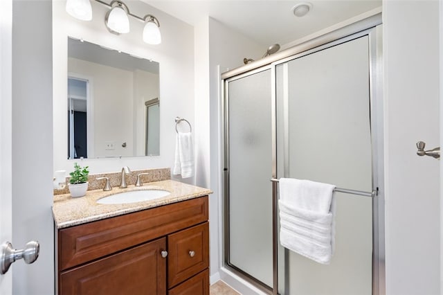 bathroom with vanity and a shower with shower door