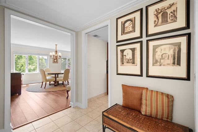 corridor featuring light hardwood / wood-style floors, a chandelier, and crown molding