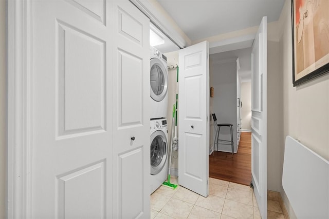 clothes washing area with stacked washer and dryer and light hardwood / wood-style flooring