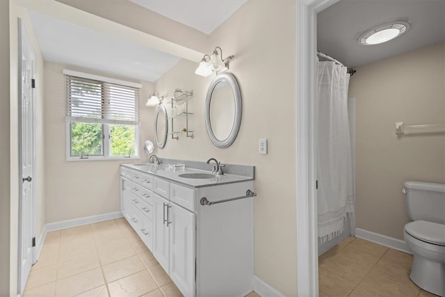 bathroom featuring tile patterned flooring, vanity, and toilet