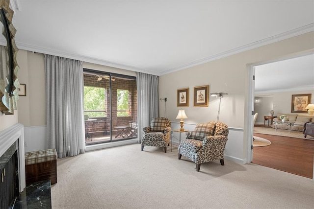 sitting room featuring carpet and crown molding