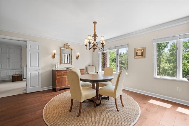 dining area with dark hardwood / wood-style floors, crown molding, and a notable chandelier