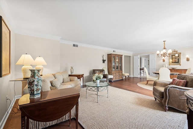 living room featuring wood-type flooring, a chandelier, and ornamental molding