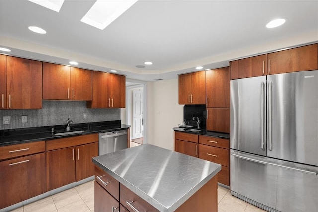 kitchen featuring a kitchen island, appliances with stainless steel finishes, light tile patterned floors, decorative backsplash, and sink