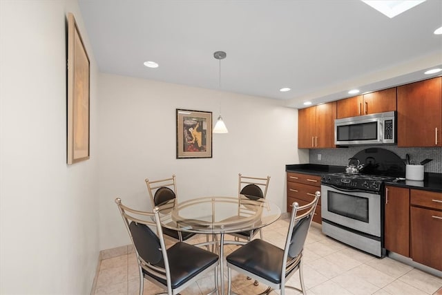 kitchen with pendant lighting, decorative backsplash, appliances with stainless steel finishes, and light tile patterned floors