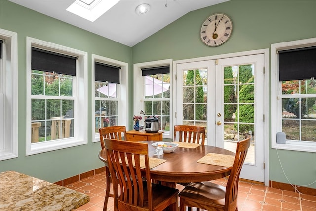 sunroom with vaulted ceiling with skylight, a wealth of natural light, and french doors