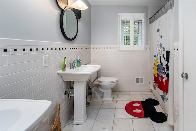 bathroom with toilet, tile walls, tile patterned flooring, and curtained shower