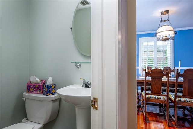 bathroom with ornamental molding, wood-type flooring, a chandelier, and toilet