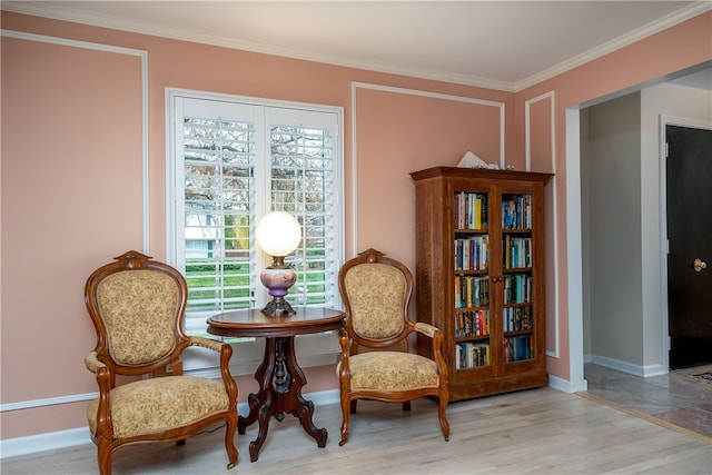 living area with light wood-type flooring and ornamental molding