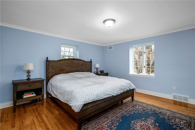 bedroom with hardwood / wood-style floors and crown molding