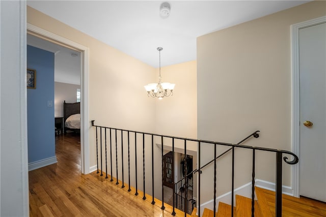 hallway featuring an inviting chandelier and hardwood / wood-style flooring