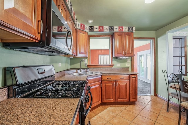 kitchen featuring french doors, black range with gas cooktop, sink, and light tile patterned floors