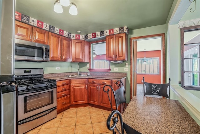 kitchen featuring stainless steel appliances, sink, and light tile patterned floors