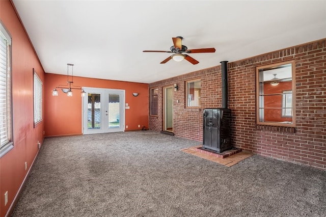 unfurnished living room with brick wall, ceiling fan, and carpet floors