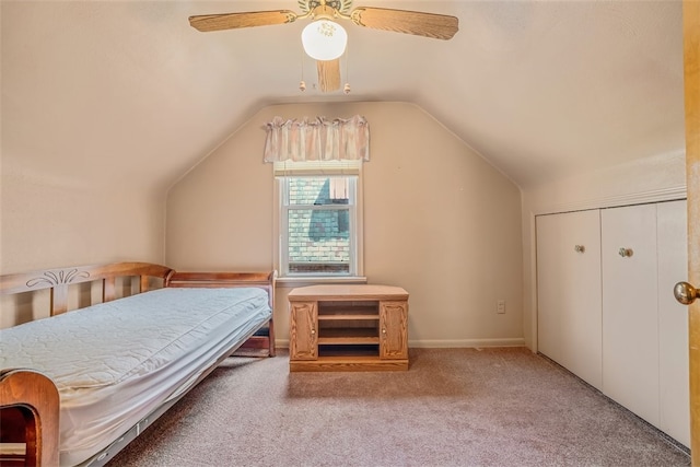 bedroom featuring ceiling fan, a closet, vaulted ceiling, and light colored carpet