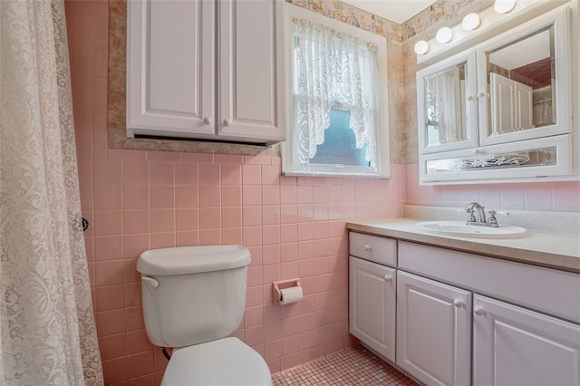 bathroom featuring tile walls, vanity, tile patterned floors, and toilet