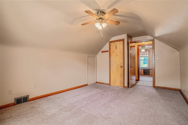 additional living space featuring light colored carpet, ceiling fan, and vaulted ceiling