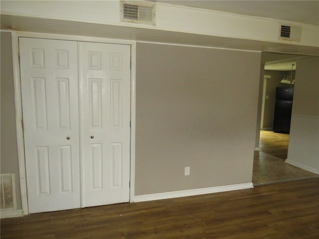 interior space featuring black fridge, dark wood-type flooring, and a closet