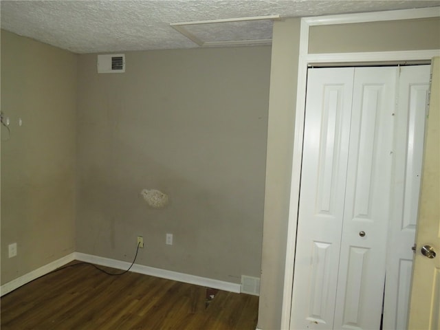 washroom with a textured ceiling and dark hardwood / wood-style floors